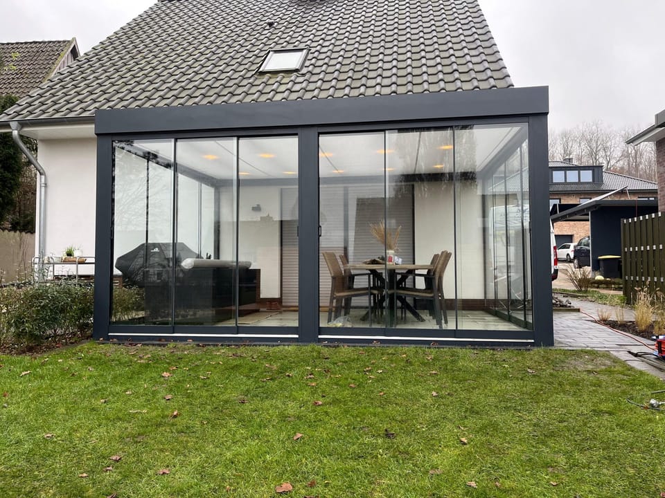 Green-Cube mit Glasschiebewänden rundum und LED-Sparrenbeleuchtung
