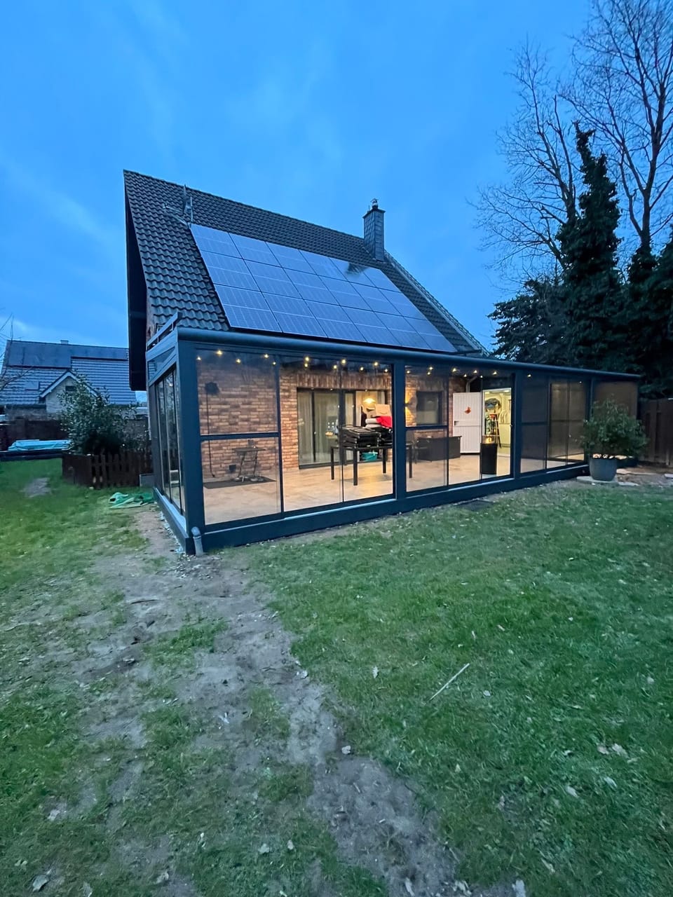 Beleuchteter Wintergarten am Abend