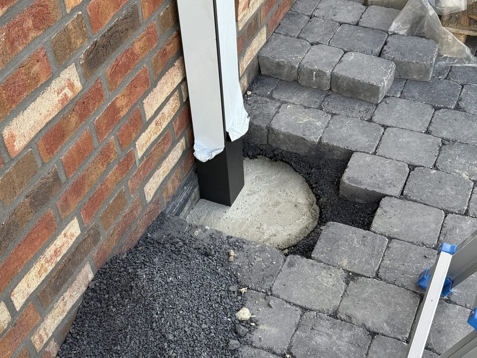 Pfosten des Carports auf einem Punktfundament aus Beton während der Montage
